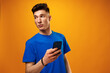 © fotofabrika - Young man using smartphone against yellow background