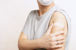 © myboys.me - Side effects of Covid 19 vaccines concept. Crop shot of a woman with adhesive plaster or band aid, she squeezed her arm because of muscle pain, one of a mild side effect. Coronavirus, Fatigue, Problem
