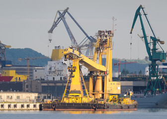  
CRANE SHIP - A specialized yellow machine moored at the quay of seaport 