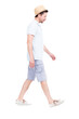 © Mediaphotos - Vertical full length side view portrait of handsome bearded Caucasian man wearing summer outfit with hat walking somewhere, white background