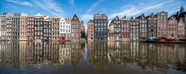 Wall Mural - Panoramic view of traditional houses along the Damrak canal in Amsterdam, Netherlands