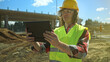 © M-Production - Builder with tablet pc at road junction construction site.