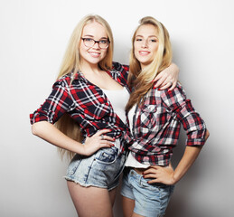 lifestyle, emotion and people concept: Two young girl friends standing together and having fun.