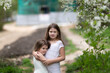 © natalialeb - Cute little girls kids girlfriends hugging among the foliage and flowers, the concept of girlish friendship and secrets, childhood in summer