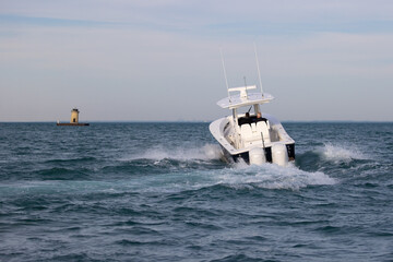 Wall Mural - powerboat speeding towards a lighthouse.