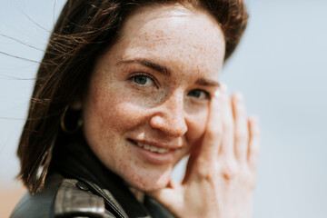 Side view of  a woman in leather jacket standing in a park