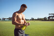 © Wavebreak Media - Caucasian muscular shirtless man holding water taking a break during exercise outdoors