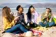 © Wavebreak Media - Happy group of diverse female friends having fun, siting on the beach and eating