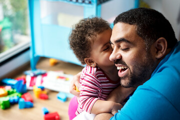 Little girl kissing dad on the cheek