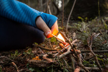 Children's Hands Holding A Burning Match In A Dry Forest. Forest Fires And Sloppy Fire Handling