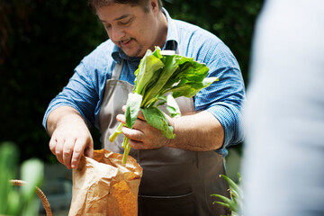 Man buying fresh organic vegetable from market