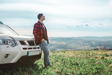 Poster - man standing near suv car at the top of the mountain