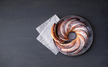 Delicious Cupcake In The Shape Of A Spiral With A Cut Piece On A Plate On A Gray Background. Top View. Place For Text  