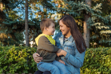 Wall Mural - portrait of a happy young mother with a young son in the park. the concept of happy motherhood