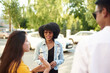 © etonastenka - Young people having fun outdoors. A group of multi-ethnic friends are talking and laughing while standing in the street