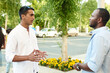 © etonastenka - Happy two multiracial male best friends talking while standing in the street, african guy talking to afghan buddy at outdoor meeting. Smiling multiethnic young people, multicultural friendship reunion