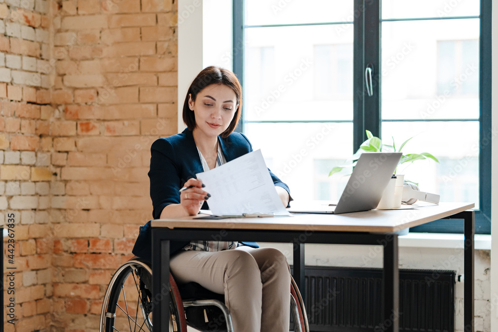 Young disabled business woman in wheelchair working