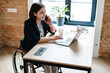 © Drobot Dean - Young disabled business woman in wheelchair working