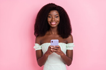 Sticker - Photo of young attractive afro girl happy positive smile use smartphone blogger social isolated over pink color background