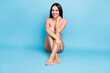 © deagreez - Full body photo of cute brown hairdo lady sit touch her skin without clothes isolated on blue color background