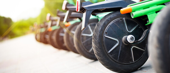 A close-up view of the wheels of green rental city scooters.