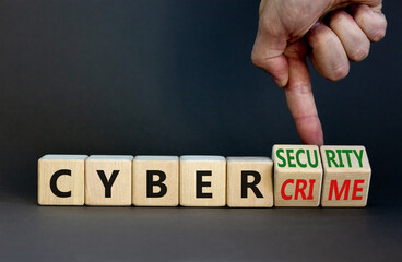 Cyber-security vs cybercrime symbol. Businessman turns wooden cubes, changes words Cybercrime to cyber-security. Beautiful grey background. Cyber-security vs cybercrime concept. Copy space.