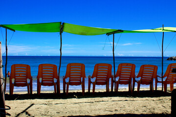 Summer in the tropical paradises of the Caribbean, under umbrellas on the shore of the blue sea