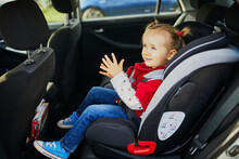 Adorable Toddler Girl In Modern Car Seat