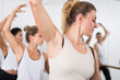 © JackF - Group of people doing exercises using barre in gym with focus to fit athletic toned ..woman in foreground in health and fitness concept