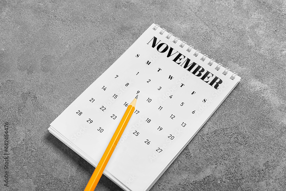 Flip paper calendar and pencil on grunge background