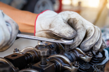 Auto mechanic adjusting car engine with wrench, Automotive repair service in workshop