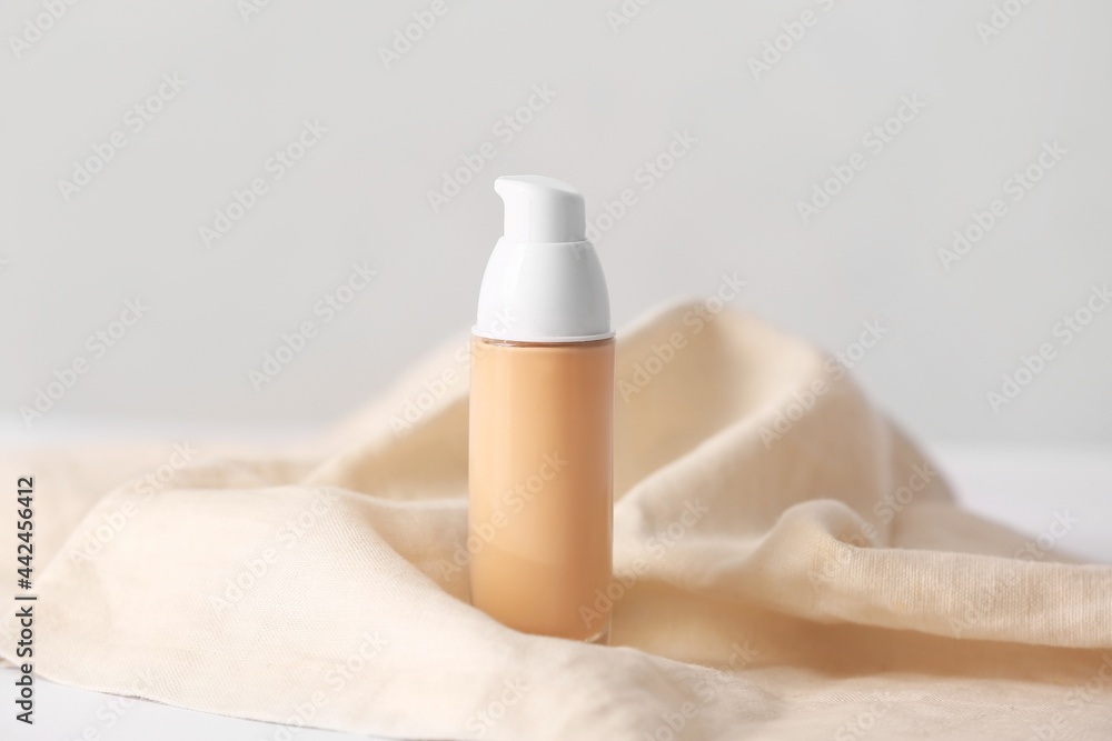 Bottle of makeup foundation on light background
