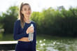 © fotofabrika - Portrait of young beautiful woman wearing blue sportswear drinking water at park