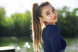 © fotofabrika - Portrait of a young smiling woman wearing sportswear in morning park
