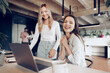 © fotofabrika - Two young happy businesswomen celebrating project success in office
