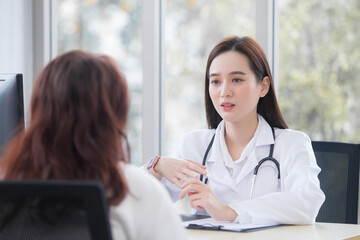 Asian professional woman doctor suggests healthcare solution to her patient elderly in examination room at hospital.