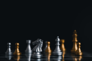 Gold king winner surrounded with silver chess pieces on chess board game competition.concept strategy, leadership and success business.