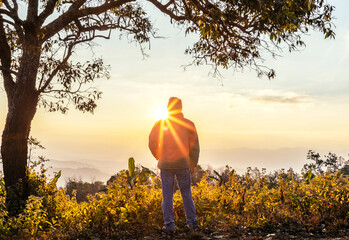 Wall Mural - silhouette male travel enjoying sunset on mountain