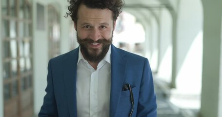 Poster - long bearded happy man holding coffee and telephone, checking social media, looking up, smiling and laughing in front of city background outside