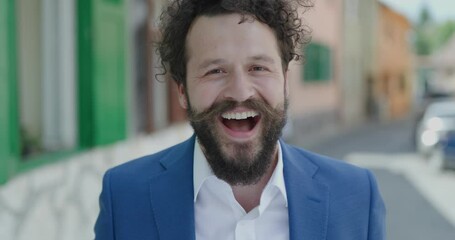 Poster - close up of happy smart casual man standing outside and smiling while camera is zooming in in a close up view in a medieval city background