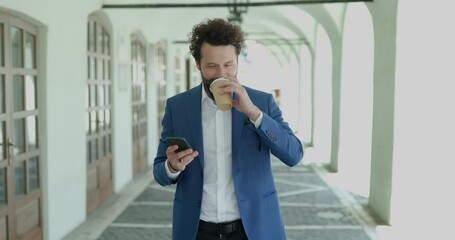 Poster - sexy curly hair man holding telephone, scrolling and checking messages, drinking coffee and laughing outside against city background