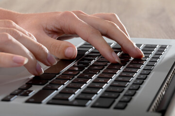 Close up of caucasian businesswoman typing on keyboard, isolated on grey background