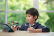 © lalalululala - Child with hearing aid constructing molecular model  in science classroom