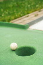 Mini Golf. White Ball Near Hole On Green Court. Summer Outdoor Game.