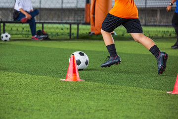 Children playing control soccer ball tactics on grass field with for training