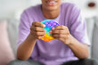 Closeup view of African American teenager playing with antistress POP IT toy at home