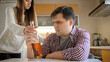 © Kyrylo Ryzhov - Angry teenage girl taking away bottle of alcohol from her drunk father drinking on kitchen. Alcoholism and addiction problems