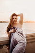© Julia Kiseleva - Beautiful young sexy woman wrapped in a blue blanket on the dawn near the water.