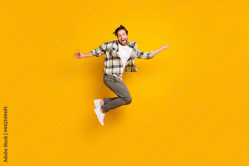 Full length photo of cheerful happy man jump up raise hands good mood smile isolated on yellow color background - obrazy, fototapety, plakaty 