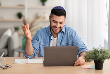 Smiling Israeli Man Having Videochat On Laptop Computer At Home